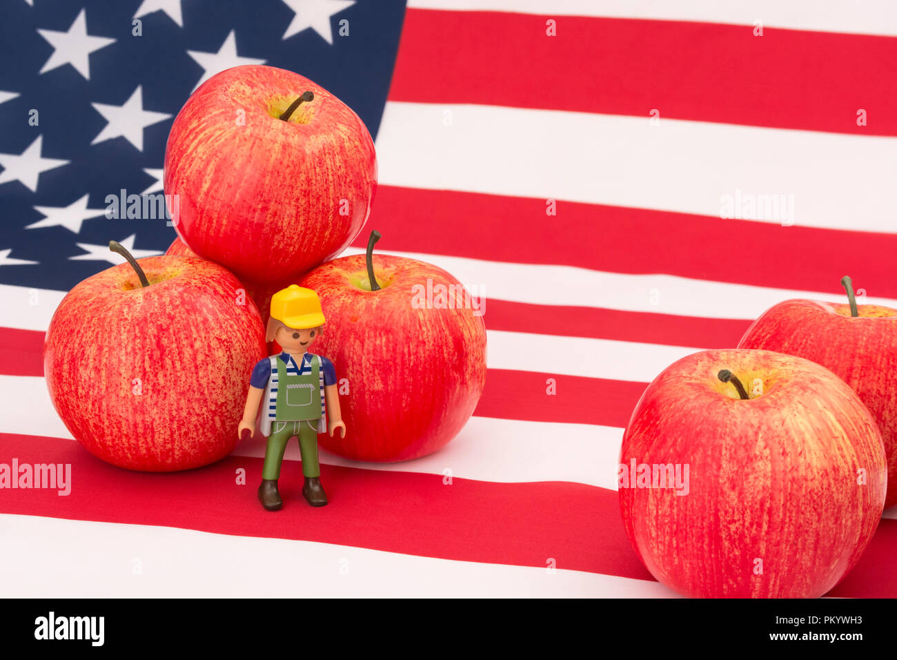 Mele rosse + bandiera americana, stelle e strisce. Per le esportazioni alimentari statunitensi, l’industria della mela statunitense, le tariffe commerciali cinesi sulle mele americane, gli agricoltori americani. Foto Stock