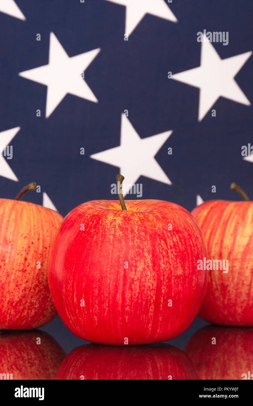 Mele rosse con bandiera americana USA / Stelle e Strisce. Esportazioni alimentari statunitensi, industria delle mele americana, Apple Day e dazi commerciali cinesi sulle importazioni di mele americane Foto Stock