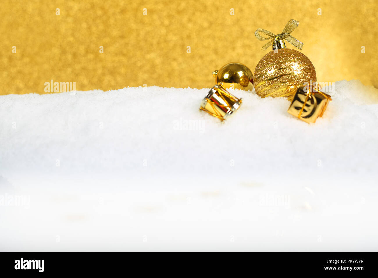 Golden decorazioni di Natale nella neve su sfondo glitter Foto Stock