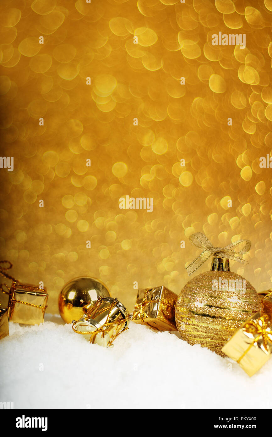 Golden decorazioni di Natale nella neve su sfondo glitter Foto Stock