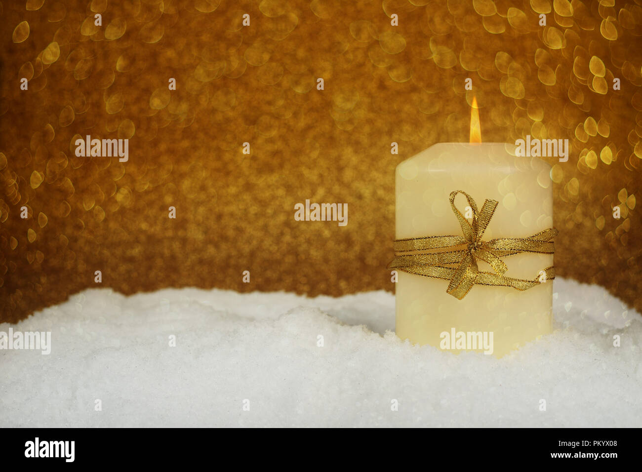 Christmas candle con golden decorazioni di Natale nella neve su sfondo glitter Foto Stock