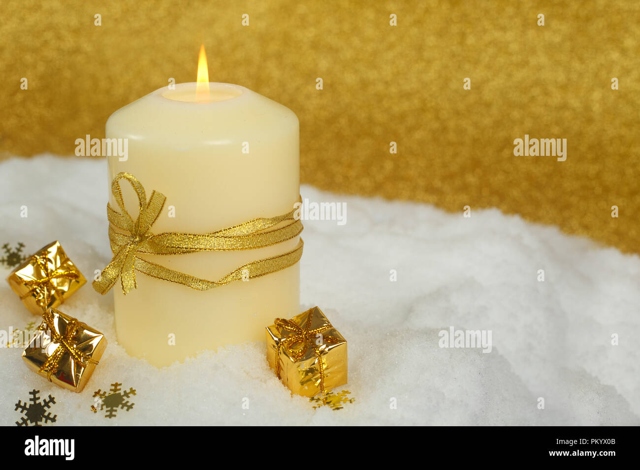 Christmas candle con golden decorazioni di Natale nella neve su sfondo glitter Foto Stock