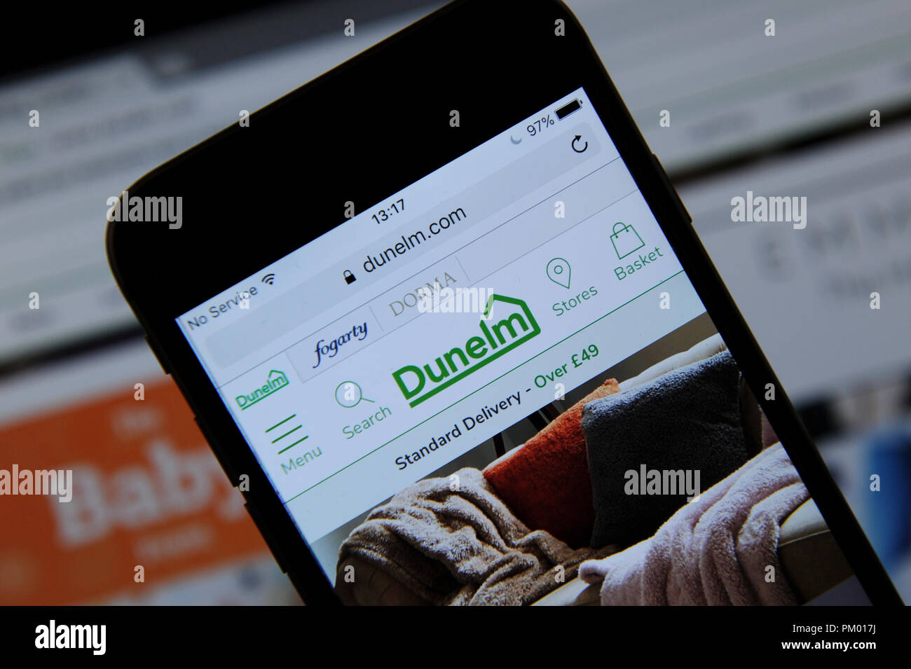 Il sito web di Dunelm visto su un telefono cellulare e lo schermo di un computer Foto Stock