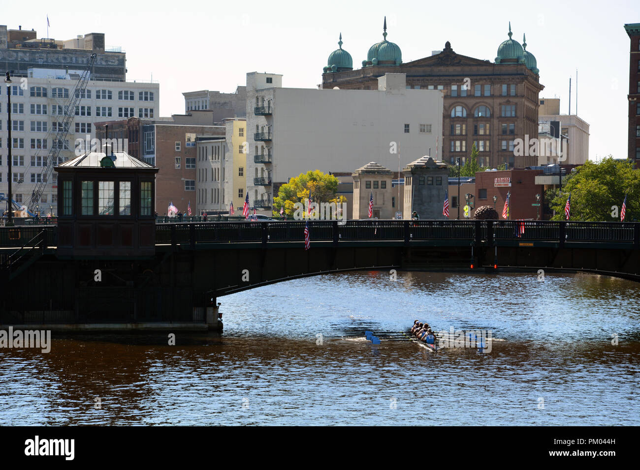 Un team di canottaggio passa sotto la strada statale ponte sul fiume Milwaukee. Foto Stock