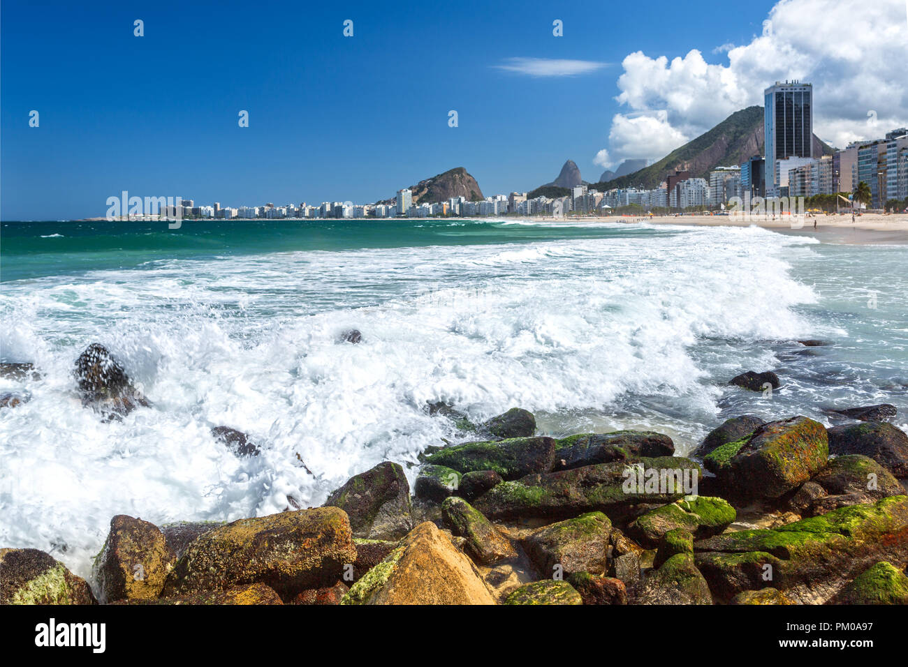 Onde infrangersi contro una costa rocciosa in Copacabana Foto Stock