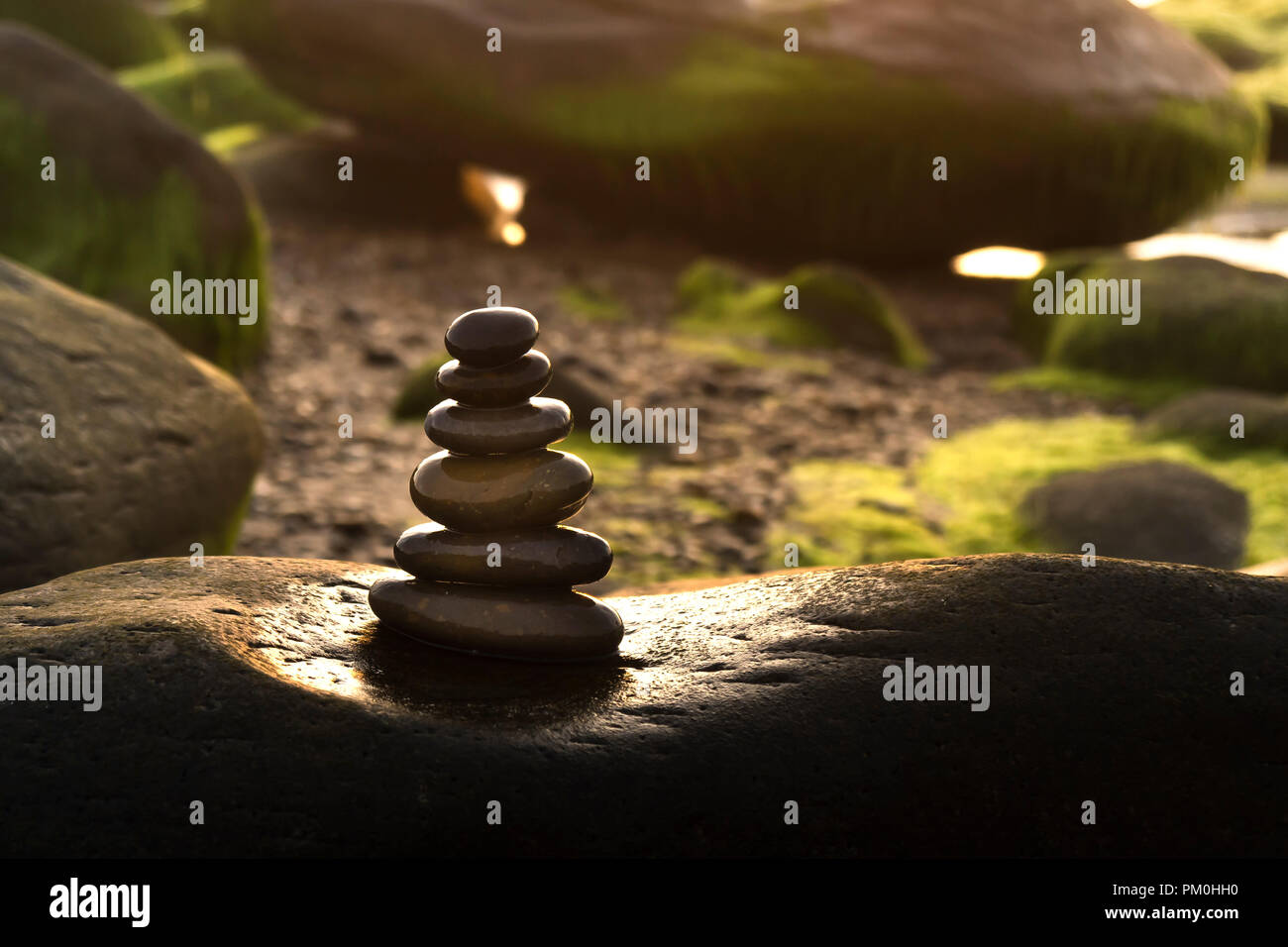 L'equilibrata pila di rocce vicino all'oceano a sunrise. Il concetto di meditazione o forte spirito o lo spirito del lavoro di squadra Foto Stock