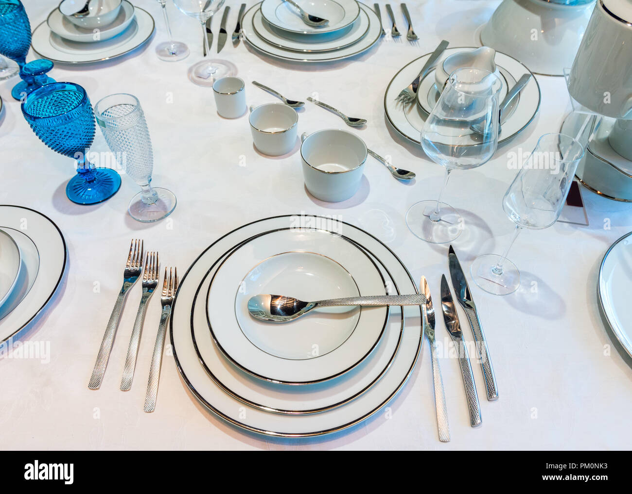 Una tabella con i bicchieri e bottiglie e stoviglie Foto Stock