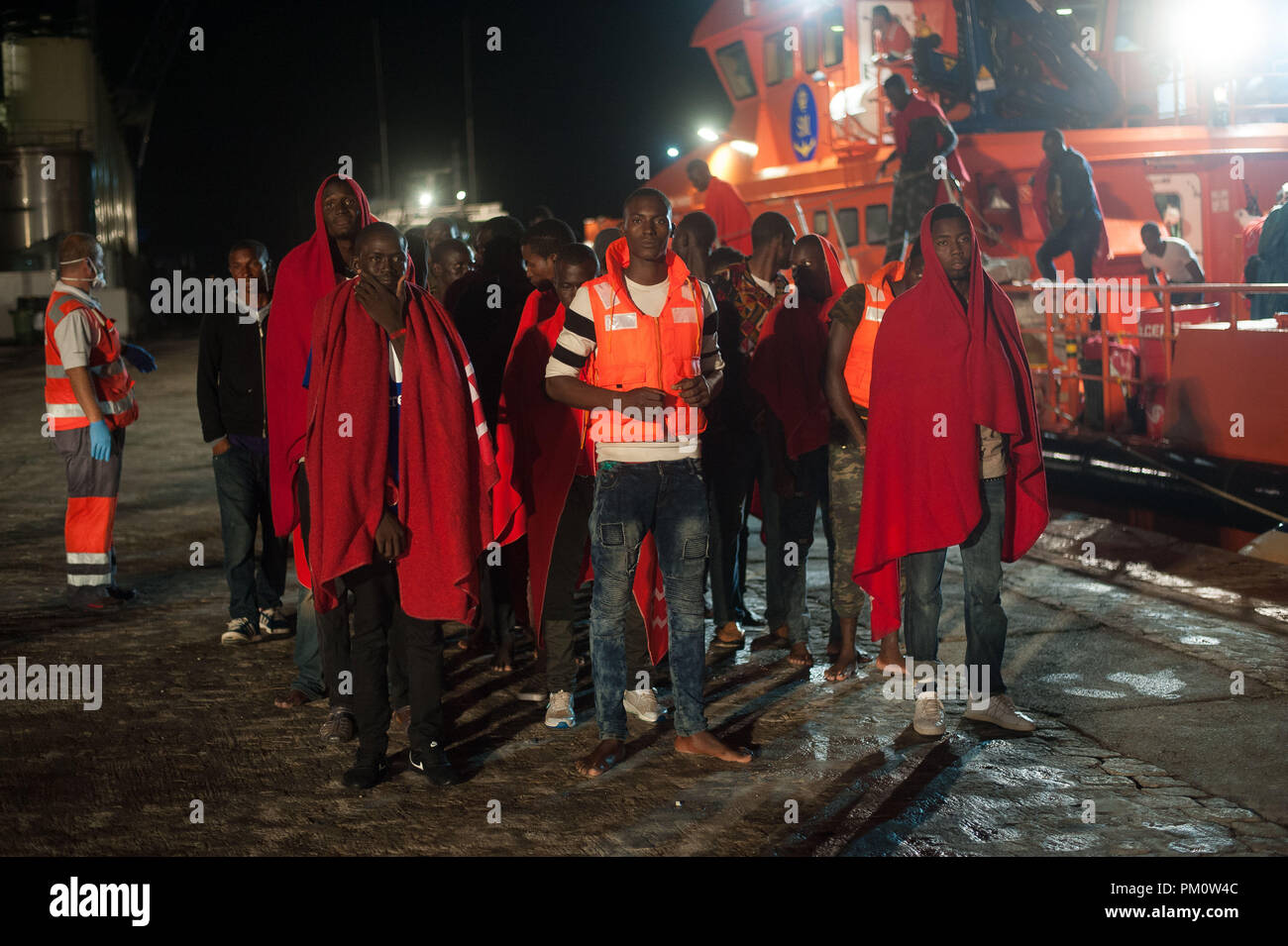 Malaga, Spagna. Xv Sep, 2018. I migranti che sono stati liberati da un gommone nel Mare Mediterraneo, attendere di essere assistito dopo il loro arrivo al porto di Malaga durante una notte piovosa.deputati spagnoli la sicurezza marittima salvato un totale di 161 migranti a bordo di gommoni di varie dal Mar Mediterraneo e li ha portati al porto di Malaga, dove sono stati assistiti dalla Croce Rossa spagnola. Credito: Gesù Merida/SOPA Immagini/ZUMA filo/Alamy Live News Foto Stock