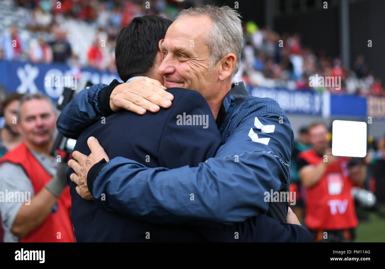 Freiburg, Germania. Xvi Sep, 2018. 16 settembre 2018, Baden-Wuerttemberg, Freiburg: Calcio - Bundesliga, SC Freiburg vs VfB Stuttgart, terza giornata in Schwarzwald Stadium. Stoccarda head coach Tayfun Korkut (L) abbracciando Freiburg head coach Christian Streich, chi è tornato sull'erba dopo una scivolata disco. Foto: Patrick Seeger/dpa - AVVISO IMPORTANTE: DFL un d DFB regolamenti vietano qualsiasi uso di fotografie come sequenze di immagini e/o quasi-video. Credito: dpa picture alliance/Alamy Live News Foto Stock