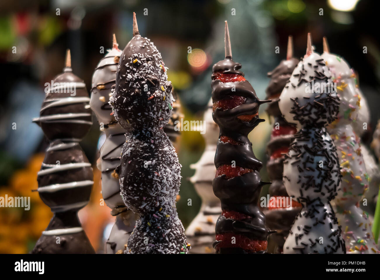 Cioccolato e frutta fresca fonduta spiedini sulla vendita a Sant Josep mercato La Boqueria di Barcellona. Regione catalana di Spagna Foto Stock