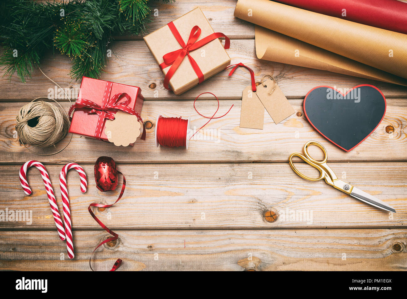 Preparazione di natale. Confezioni regalo avvolgimento su sfondo di legno, copia spazio, vista dall'alto Foto Stock