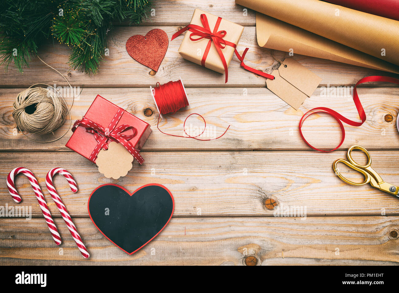 Preparazione di natale. Confezioni regalo avvolgimento su sfondo di legno, copia spazio, vista dall'alto Foto Stock
