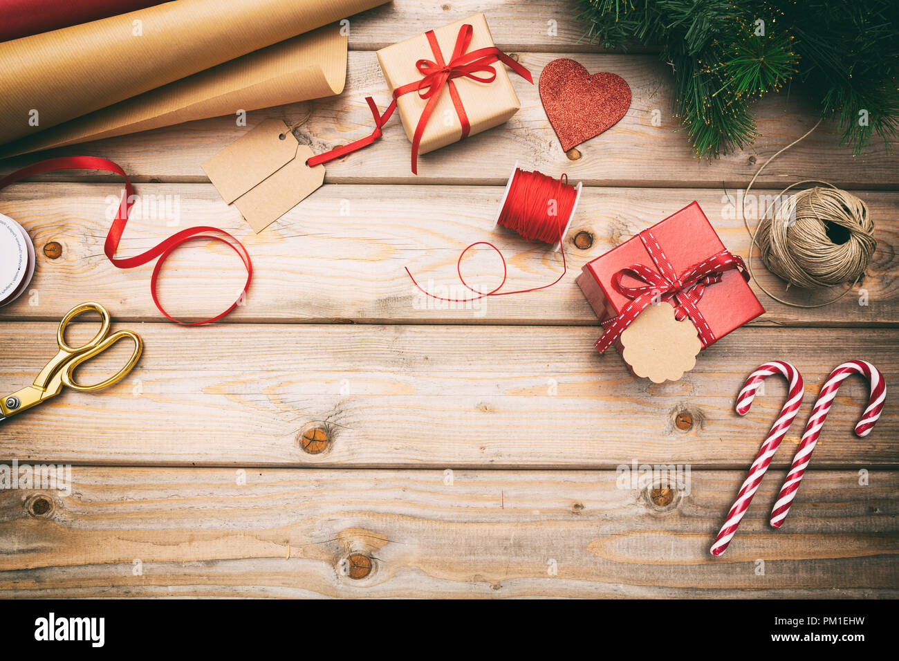 Preparazione di natale. Confezioni regalo avvolgimento su sfondo di legno, copia spazio, vista dall'alto Foto Stock