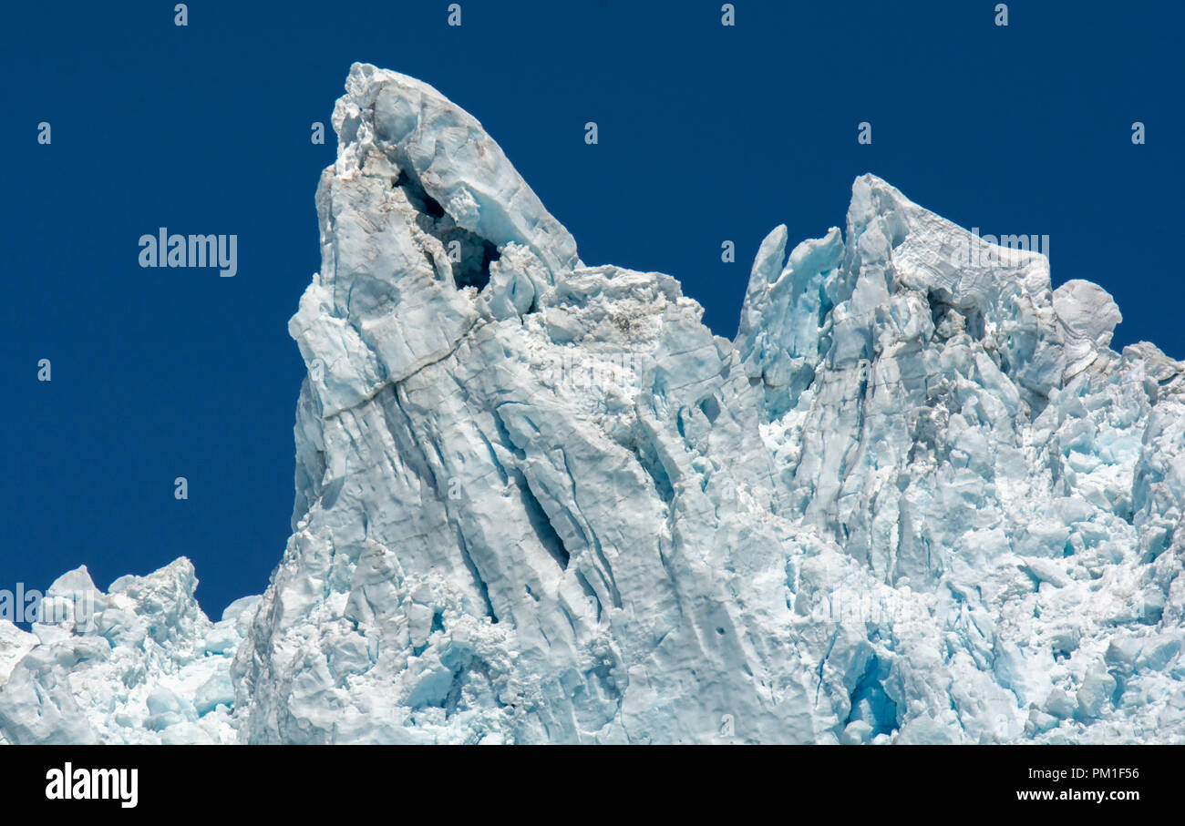 Un ghiacciaio ha spinto un Bianco azzurrognolo rotto e fabbricato colonna di ghiaccio in solido blu cielo in Alaska. Foto Stock
