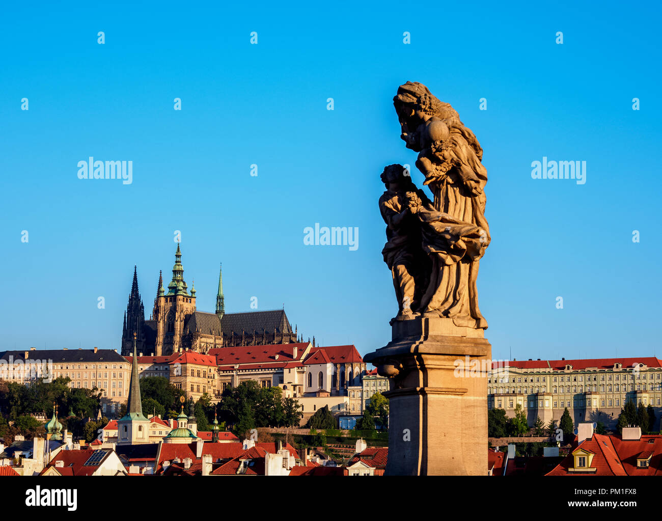 La scultura al Ponte Carlo, il castello e la cattedrale in background, Praga, Boemia Regione, Repubblica Ceca Foto Stock