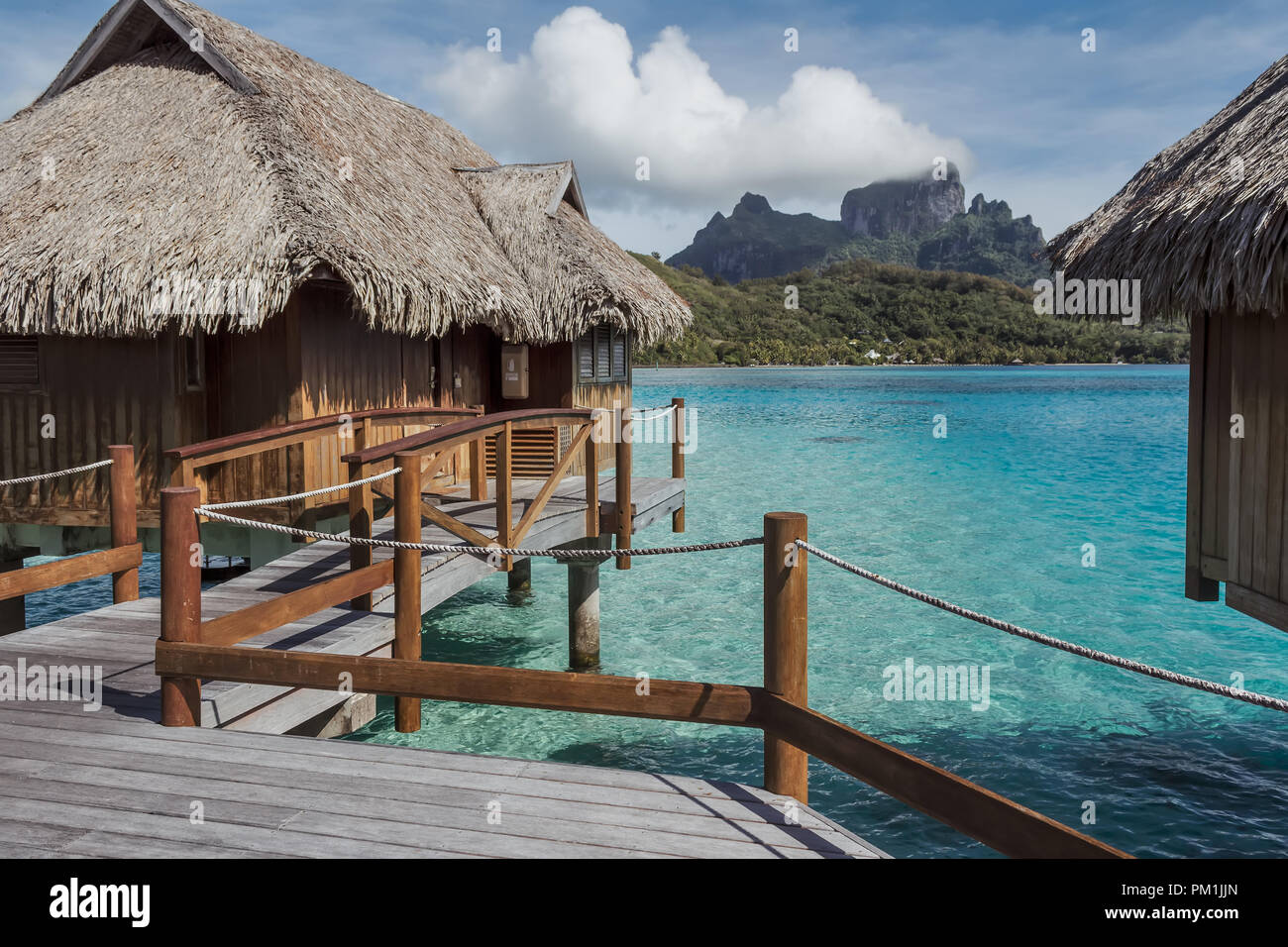 Bungalow sull'acqua e il Monte Otemanu dietro a Bora Bora, Polinesia Francese Foto Stock