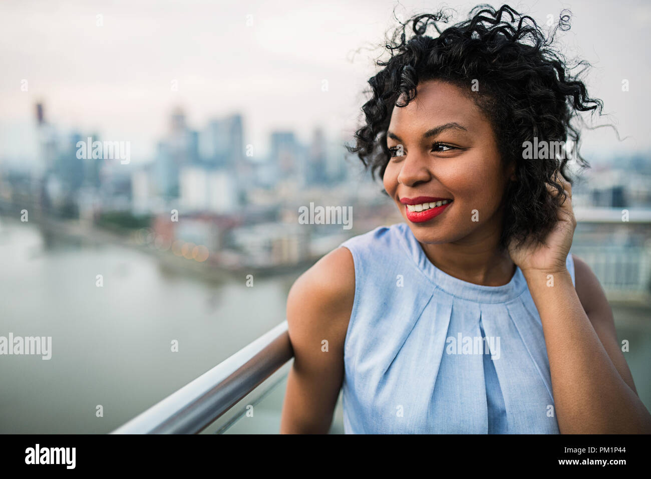 Un close-up ritratto di una donna in piedi su una terrazza a Londra. Foto Stock