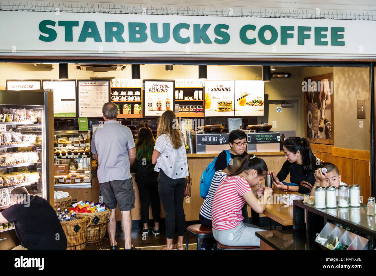 Londra Inghilterra,UK,Regno Unito Gran Bretagna,South Bank,Waterloo Station,Starbucks Coffee,cafe coffee house houses,Asian Asian Asian Asian Asian Aethnic Immigrant imm Foto Stock
