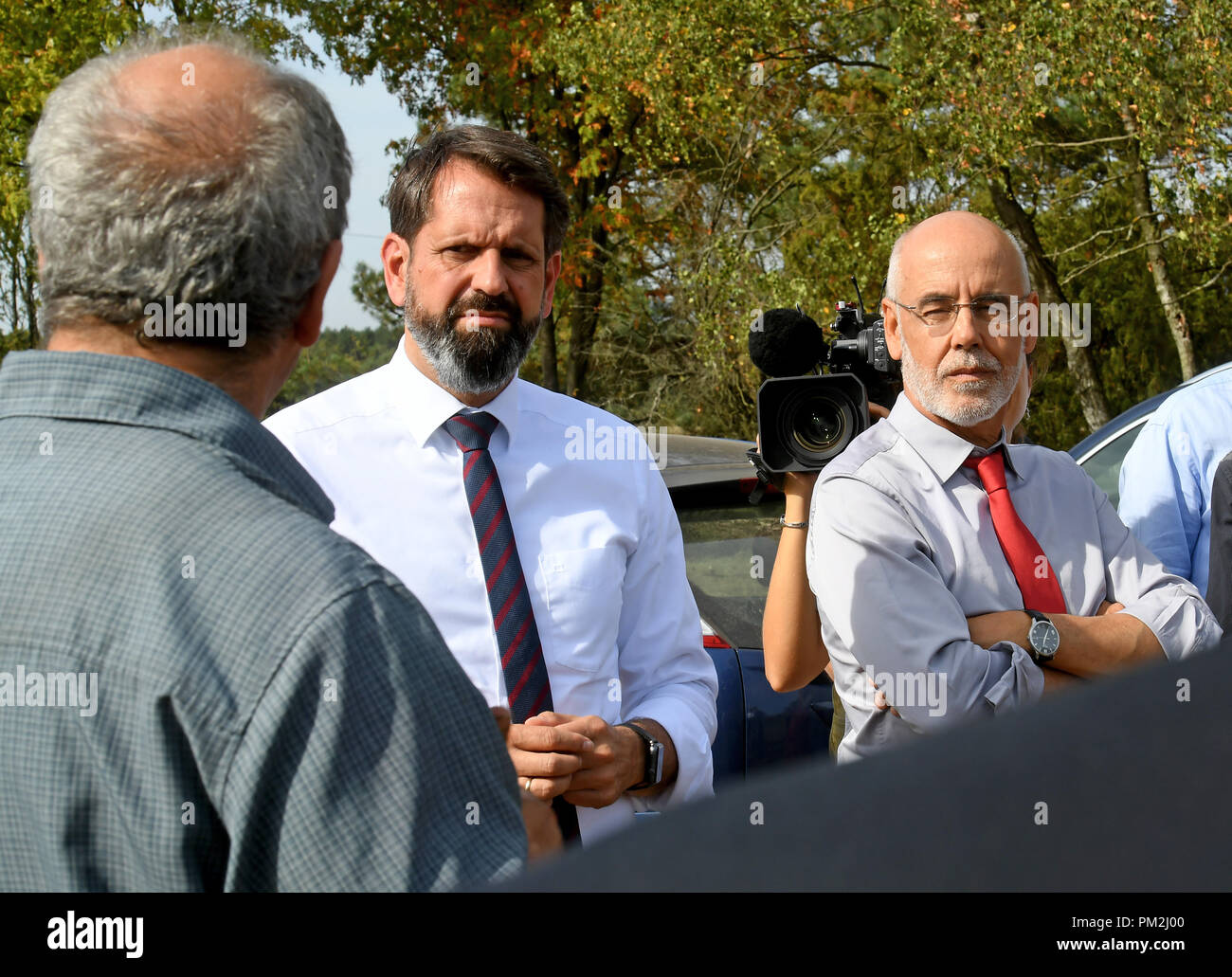 17 settembre 2018, Bassa Sassonia, Fassberg: Olaf giace (SPD, C), Ministro dell'ambiente della Bassa Sassonia e Humberto Delgado Rosa (R), Direttore della Direzione generale Ambiente della Commissione europea, parlando di Allevatore ovino Carl Kuhlmann (L) su un pascolo di ovini in Lueneburg Heath. In occasione della riunione, i problemi e le soluzioni relativi ai lupi di ritorno sono stati discussi. Foto: Holger Hollemann/dpa Foto Stock