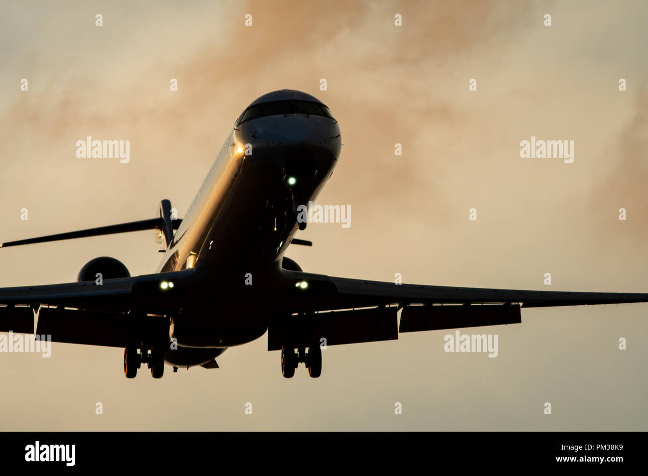 Alto contrasto di aereo a reazione con landing gear down, vista dal basso Foto Stock