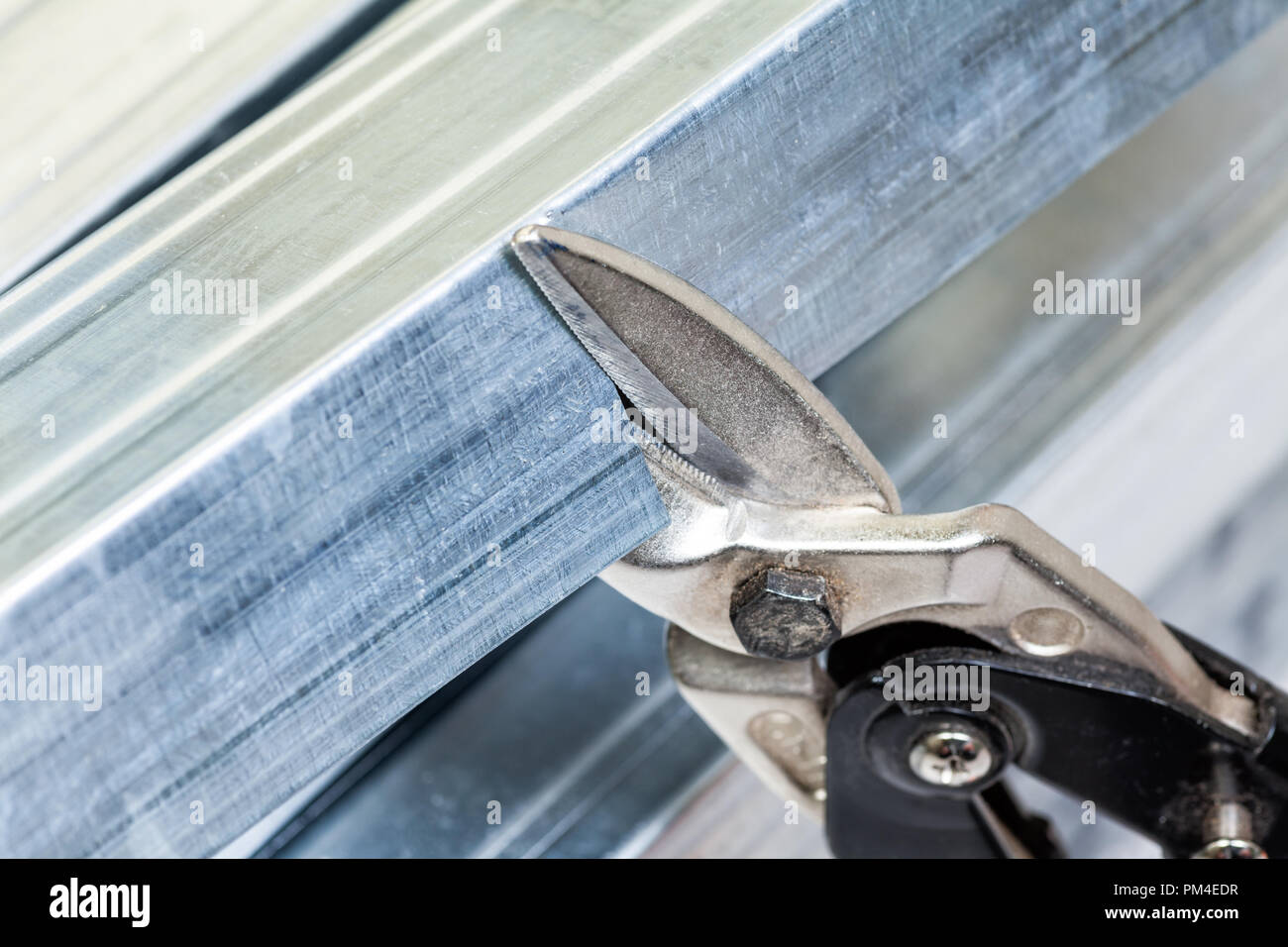 Persona che taglia un prigioniero di metallo con fresa intestare mentre la  costruzione del telaio di cartongesso Foto stock - Alamy