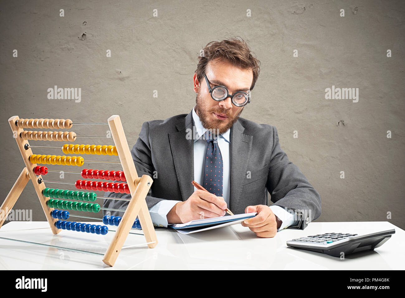 Nerd ragioniere fa il calcolo delle entrate di un'azienda Foto Stock