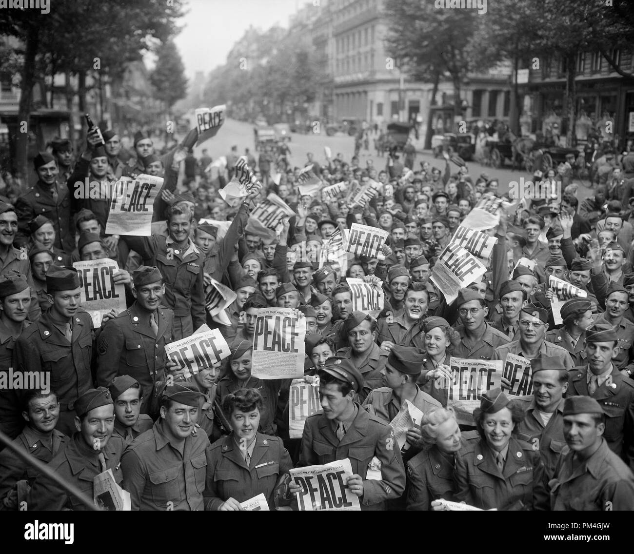 Soldati americani e le donne si riuniscono di fronte di "Rainbow Corner Red Cross Club di Parigi per festeggiare la resa incondizionata dei giapponesi. Il 15 agosto 1945. Riferimento al file # 1003 040THA Foto Stock