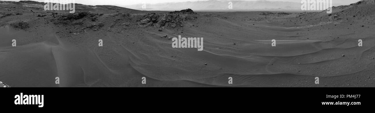 NASA Curiosità Mars rover utilizzato la sua telecamera di navigazione (Navcam) per catturare questa scena verso ovest subito dopo il completamento di una unità che ha avuto la missione di guida totale distanza oltre dieci chilometri (6.214 miglia). L'unità sul 16 aprile 2015, durante il 957th giorno Martian, o sol di curiosità di lavoro su Marte coperto 208 piedi (63,5 metri). Esso advanced rover verso ovest attraverso un sabbioso-pavimentato valley. La valle è il rover del percorso verso un sito più alto sul monte nitide rispetto a siti ha esaminato in precedenza. Riferimento al file # 1003 578THA Foto Stock