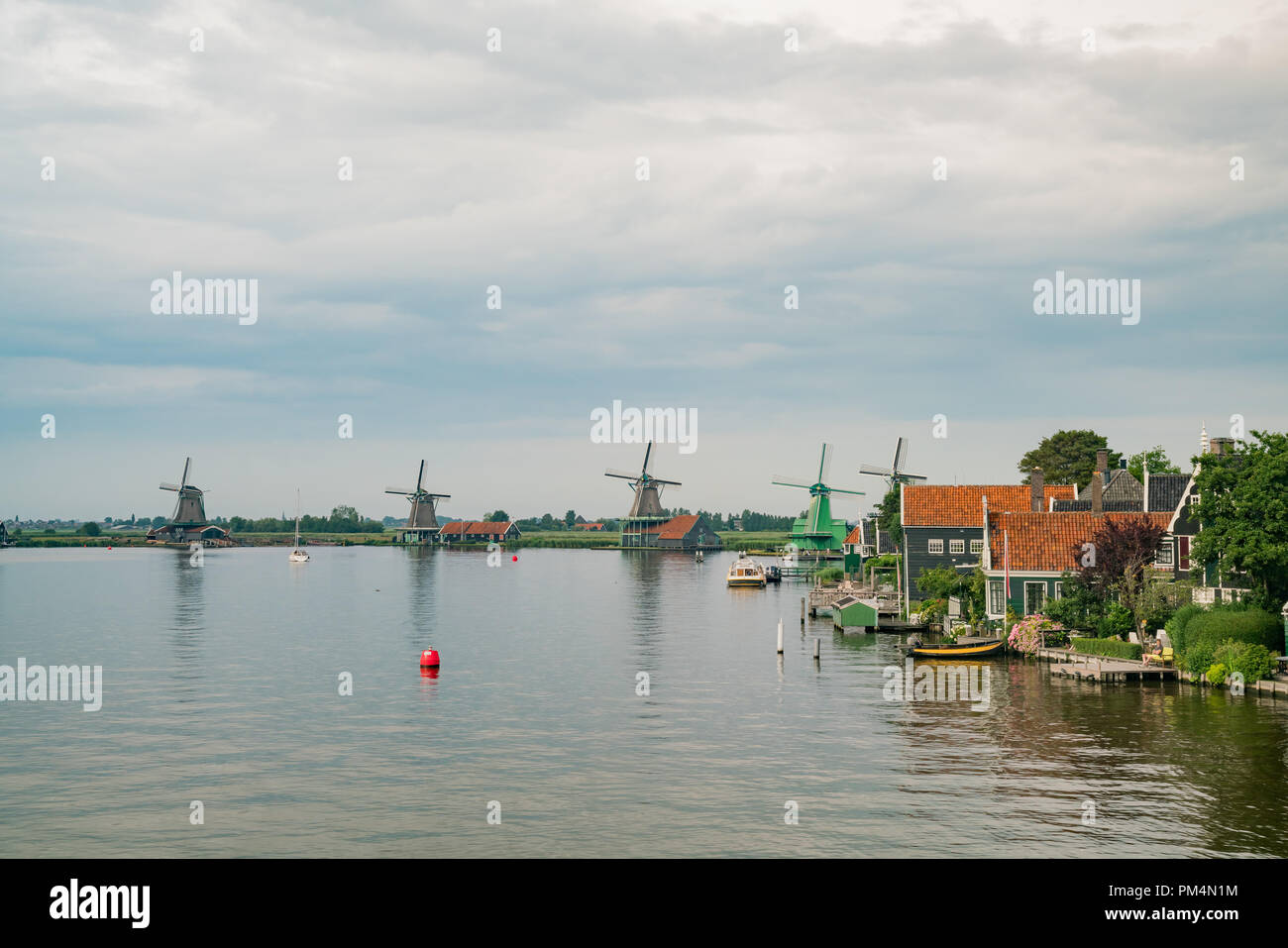 De Gekroonde Poelenburg, De Kat, Windmill De Zoeker, Houtzaagmolen het Jonge Schaap windmill e vista sul fiume a Zaandijk, Paesi Bassi Foto Stock