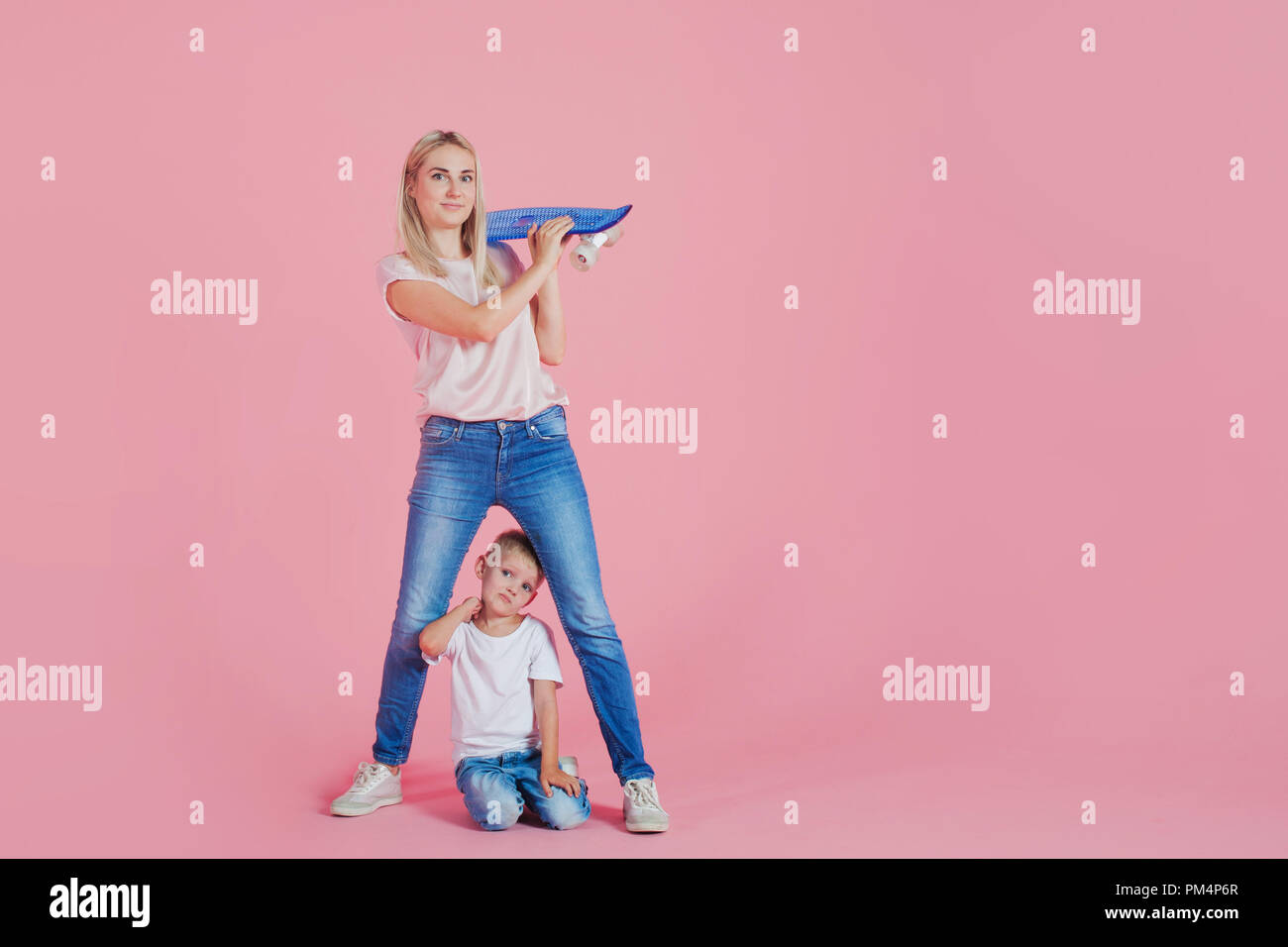 Bella bionda mom con felice figlio. Giovane donna e bambino sfondo rosa Foto Stock
