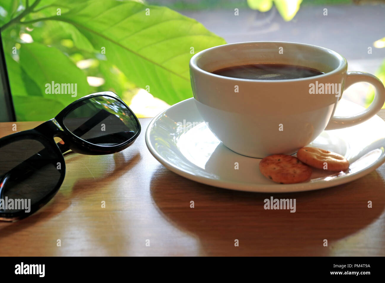 Occhiali da sole tazza di caffè sul tavolo nella caffetteria immagini e  fotografie stock ad alta risoluzione - Alamy