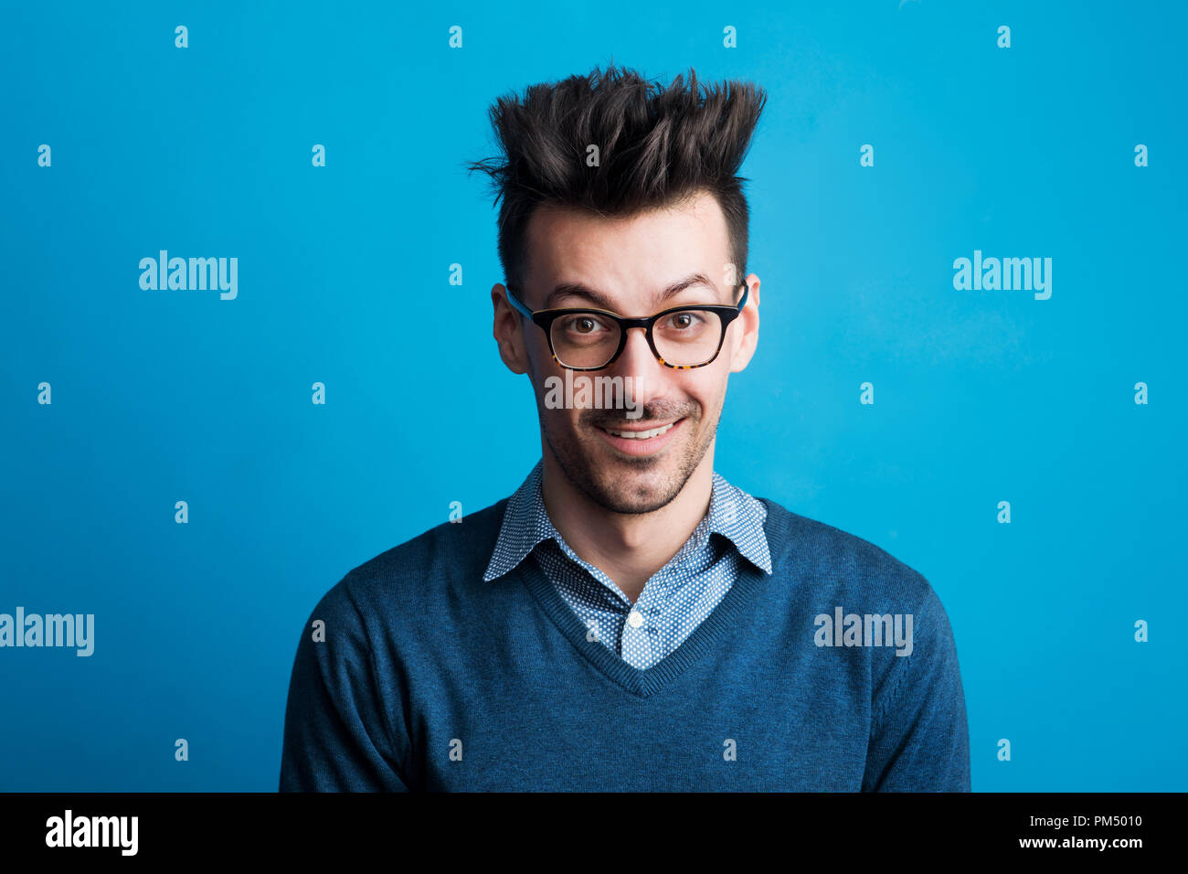 Ritratto di un giovane uomo in uno studio con un acconciatura pungenti. Foto Stock