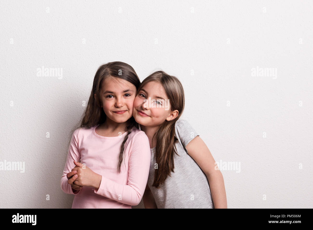 Due piccole bambine in piedi in un studio. Foto Stock