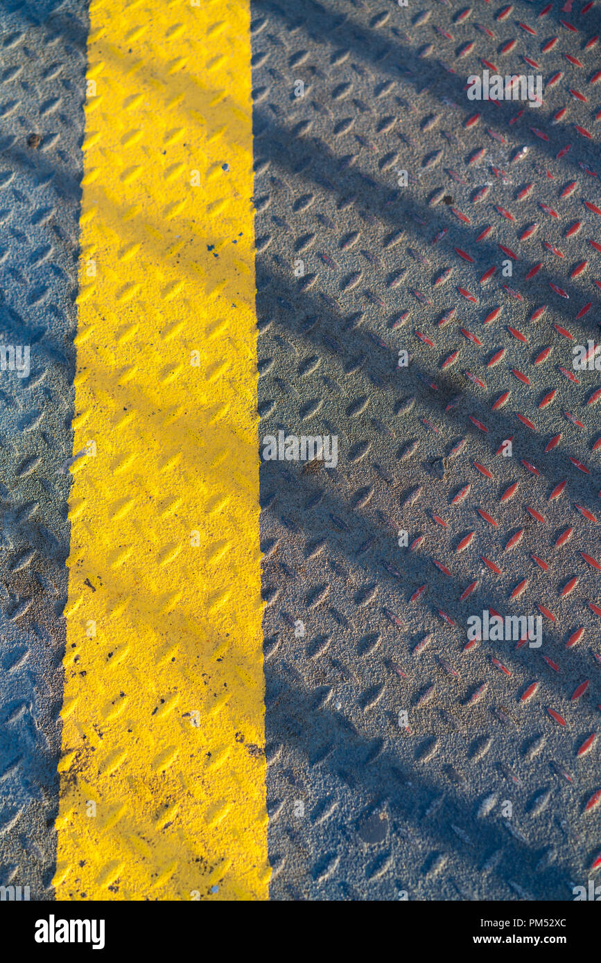 Acciaio passerella metallica con verniciato giallo linea per pedoni texture a piedi Foto Stock
