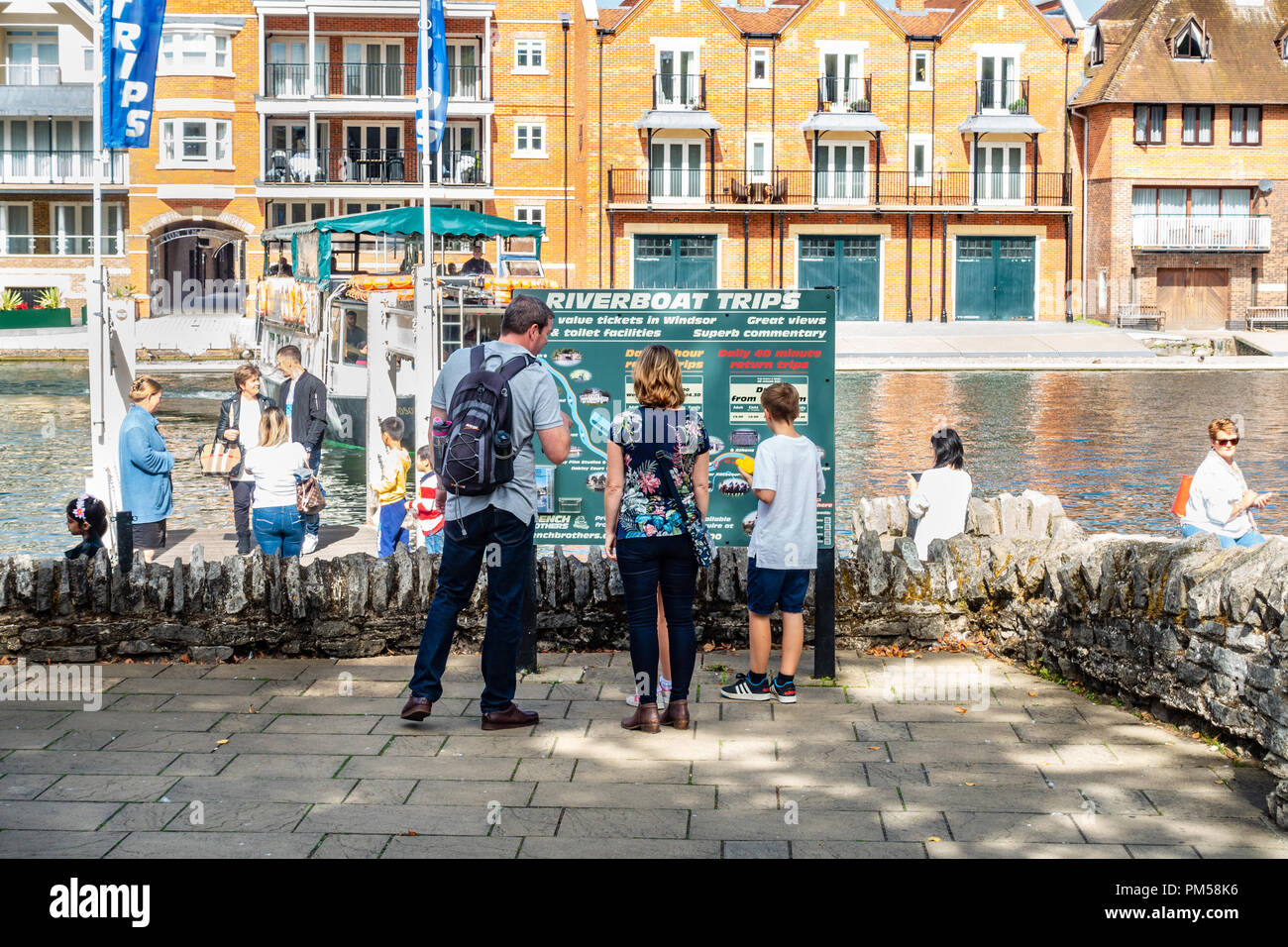 Una famiglia di arresto e leggere un segno su fiume gite in barca lungo il fiume Tamigi a Windsor. Foto Stock