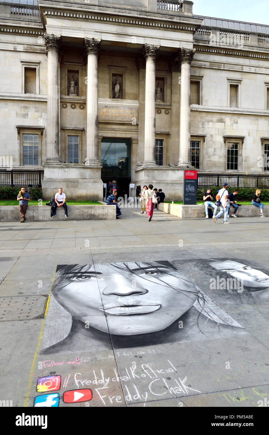 National Gallery, Trafalgar Square, Londra, Inghilterra, Regno Unito. L'artista di strada in verticale sul marciapiede Foto Stock