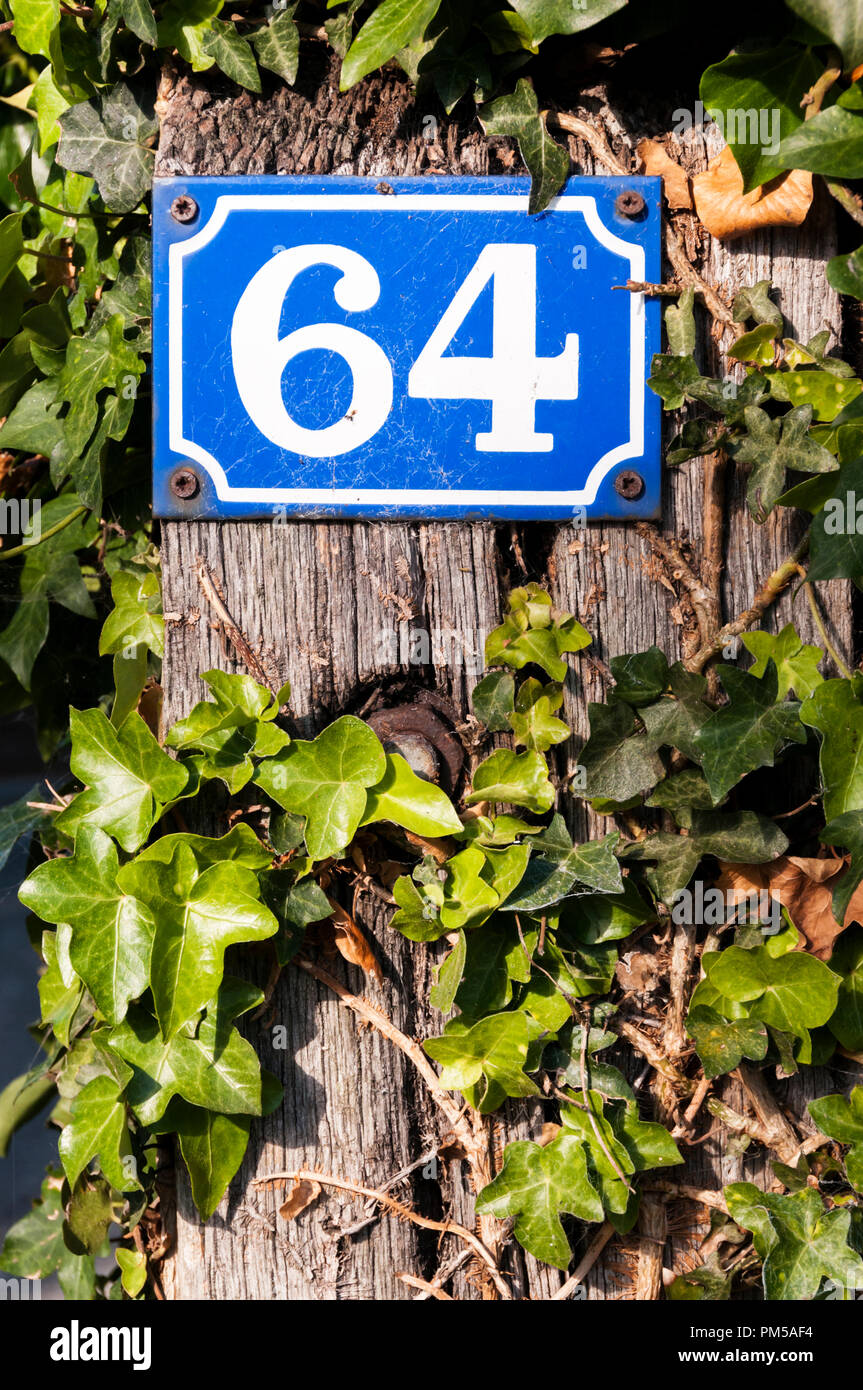 Un stile francese di metallo numero di casa. Il numero 64. Foto Stock