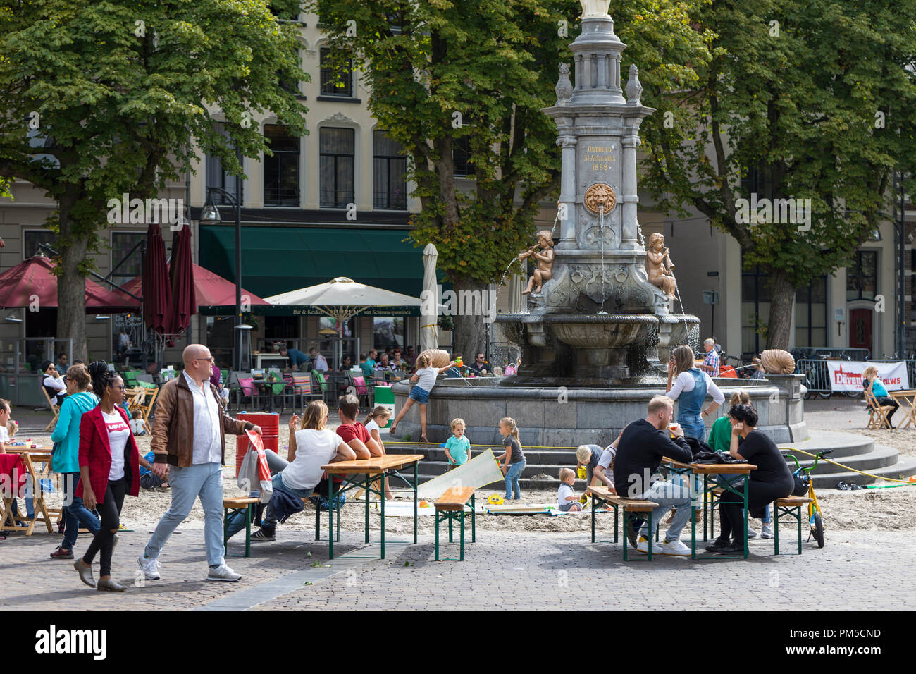 Bambini che giocano con la sabbia e acqua a sandbox improvvisata all interno della città Fontana di Deventer, Paesi Bassi Foto Stock