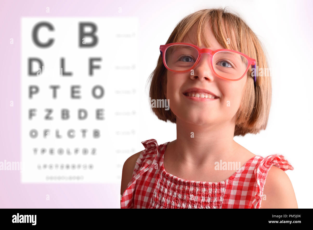 Bambino occhio verificare con la ragazza con gli occhiali e la lettera pensione in background. Concetto di revisione dell'occhio. Composizione orizzontale Foto Stock