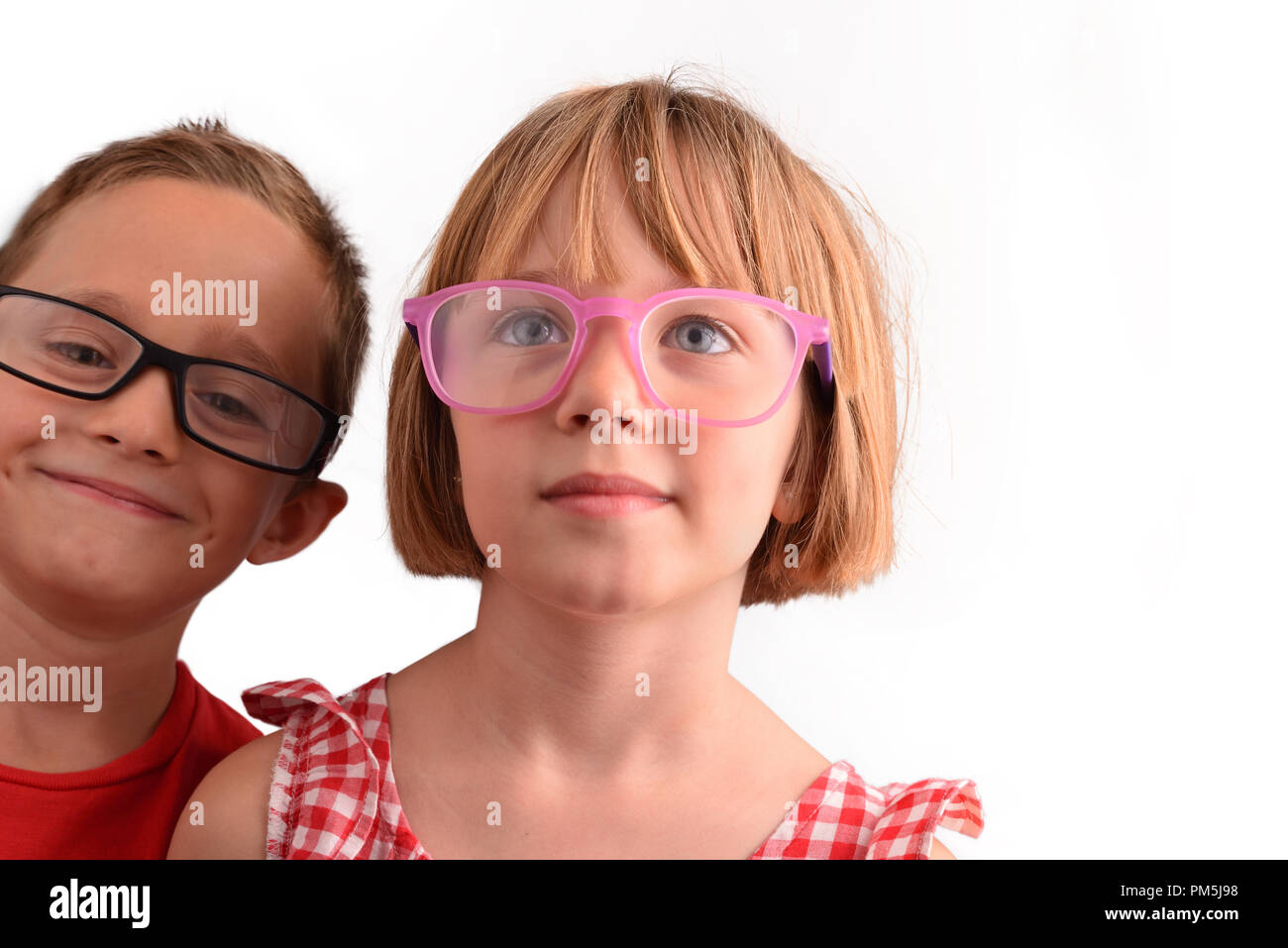 Bambini sorridenti con gli occhiali e isolato bianco sullo sfondo. Concetto di correzione visiva con gli occhiali. Composizione orizzontale Foto Stock