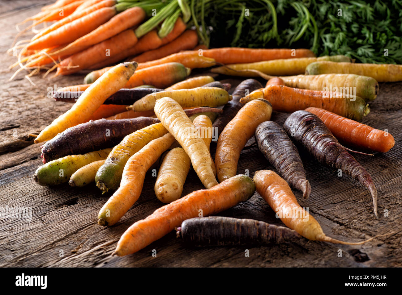 Materie fresche cimelio di organico carote su un legno rustico tavolo raccolto. Foto Stock