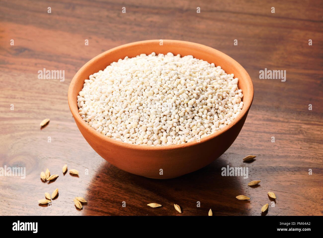 CloClose fino del Farro in un vaso di argilla su sfondo di legno vicino di Farro in un vaso di argilla su sfondo di legno Foto Stock