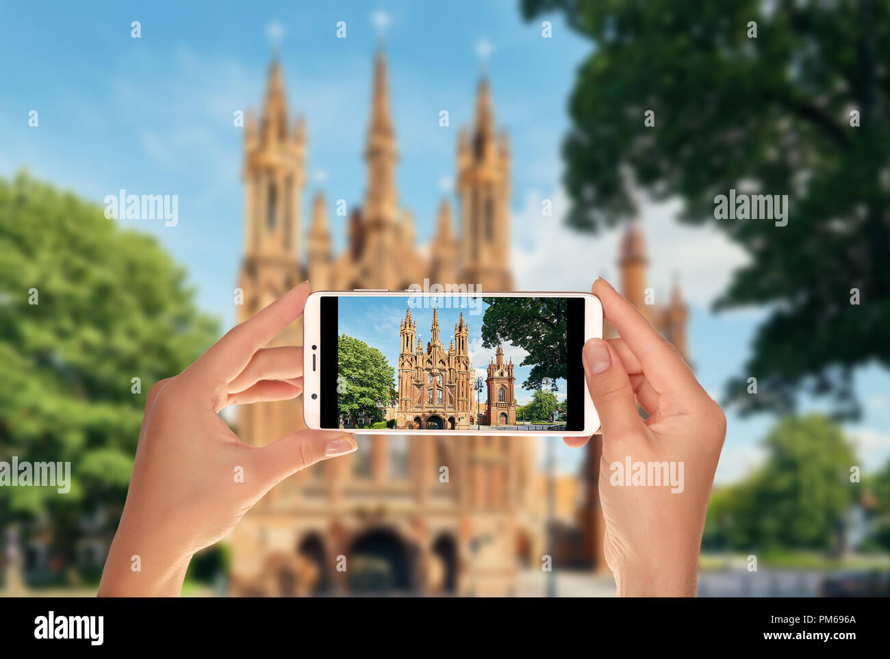 Un turista è scattare una foto della chiesa cattolica di Sant Anna a Vilnius, in Lituania su un telefono cellulare Foto Stock