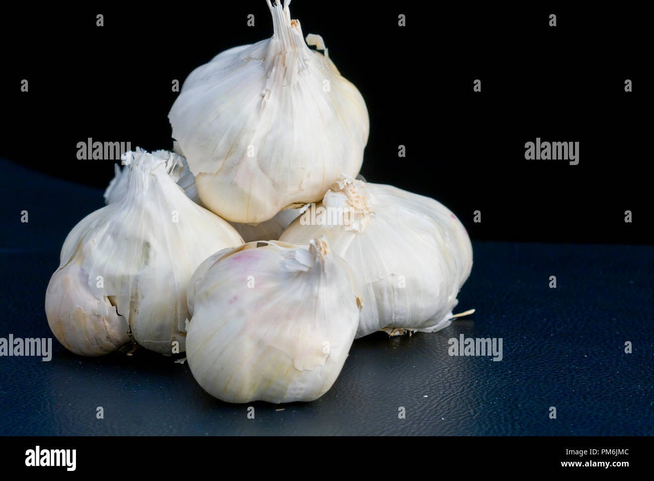 Close-up immagini di spicchi di aglio isolati su sfondo nero Foto Stock