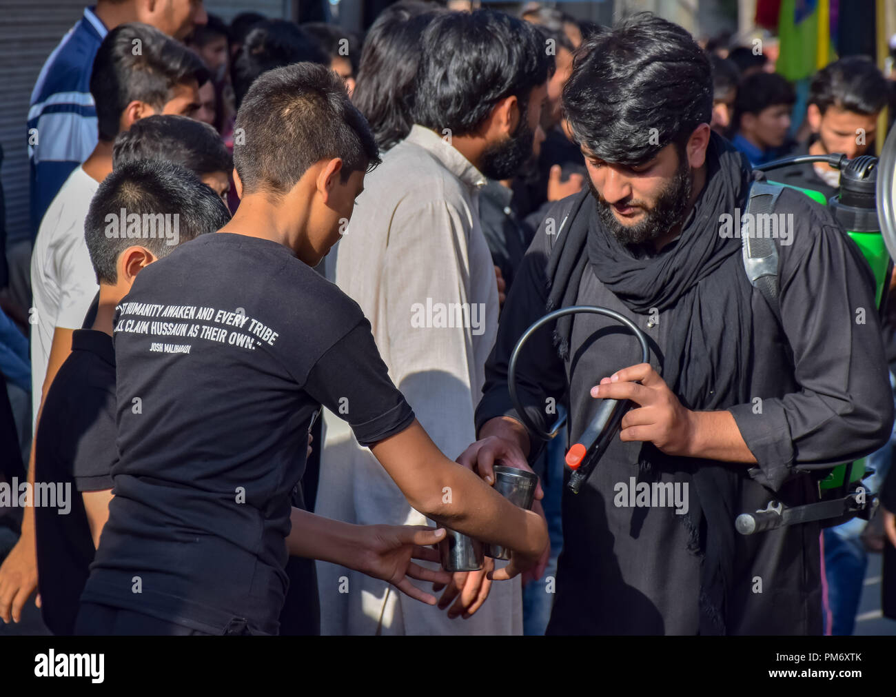 Bicchiere di acqua è dato per il Kashmir lutto sciita durante 6 giorni di Ashura processione in Srinagar il lunedì. Musulmano sciita commemora Muharram, il primo mese del calendario lunare, come mese di lutto in rimembranza del martirio profeta islamico Maometto pbsl il nipote di Imam Hussain (PBSL) che fu martirizzato il decimo giorno di Muharram nella battaglia di Karbala in 680 A.D alcuni 1400 anni fa. Foto Stock