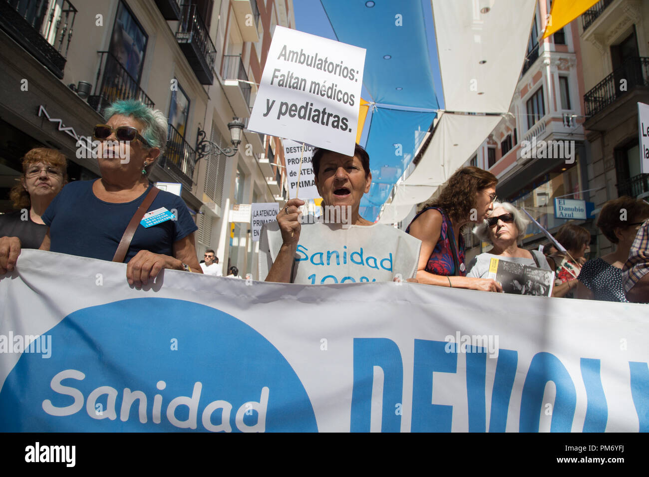 Due donne visto dietro un banner gridando slogan durante la manifestazione a difesa della salute pubblica e contro i tagli nella cura primaria della salute pubblica. Foto Stock