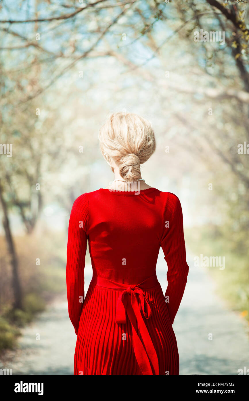 Blonde retrò donna in piedi sul viottolo di campagna in primavera Foto Stock