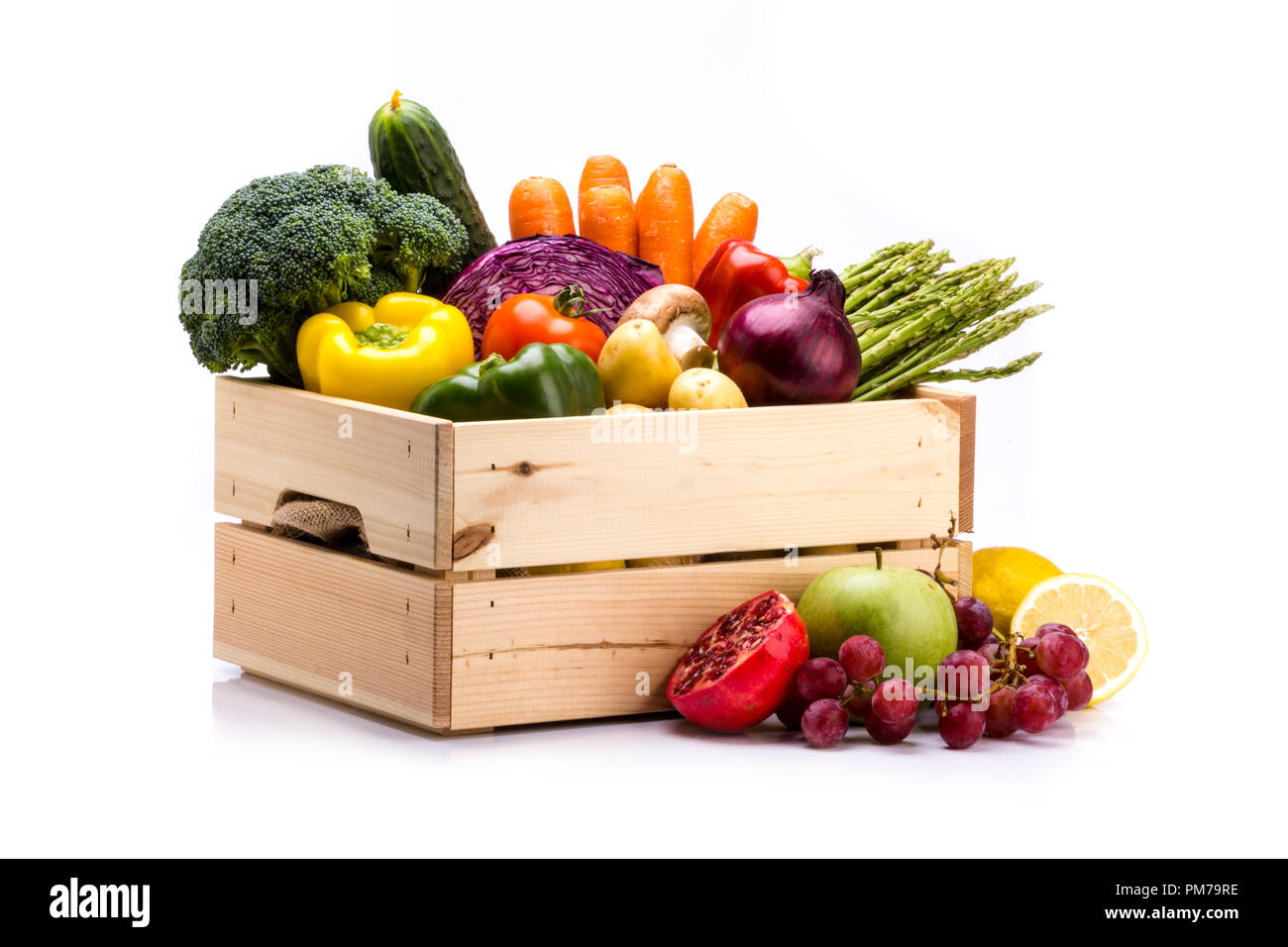 Pine scatola piena di colorati frutta e verdura fresche su uno sfondo bianco, ideale per una dieta equilibrata, contiene i broccoli, il cetriolo, la cipolla, asparagi, Foto Stock