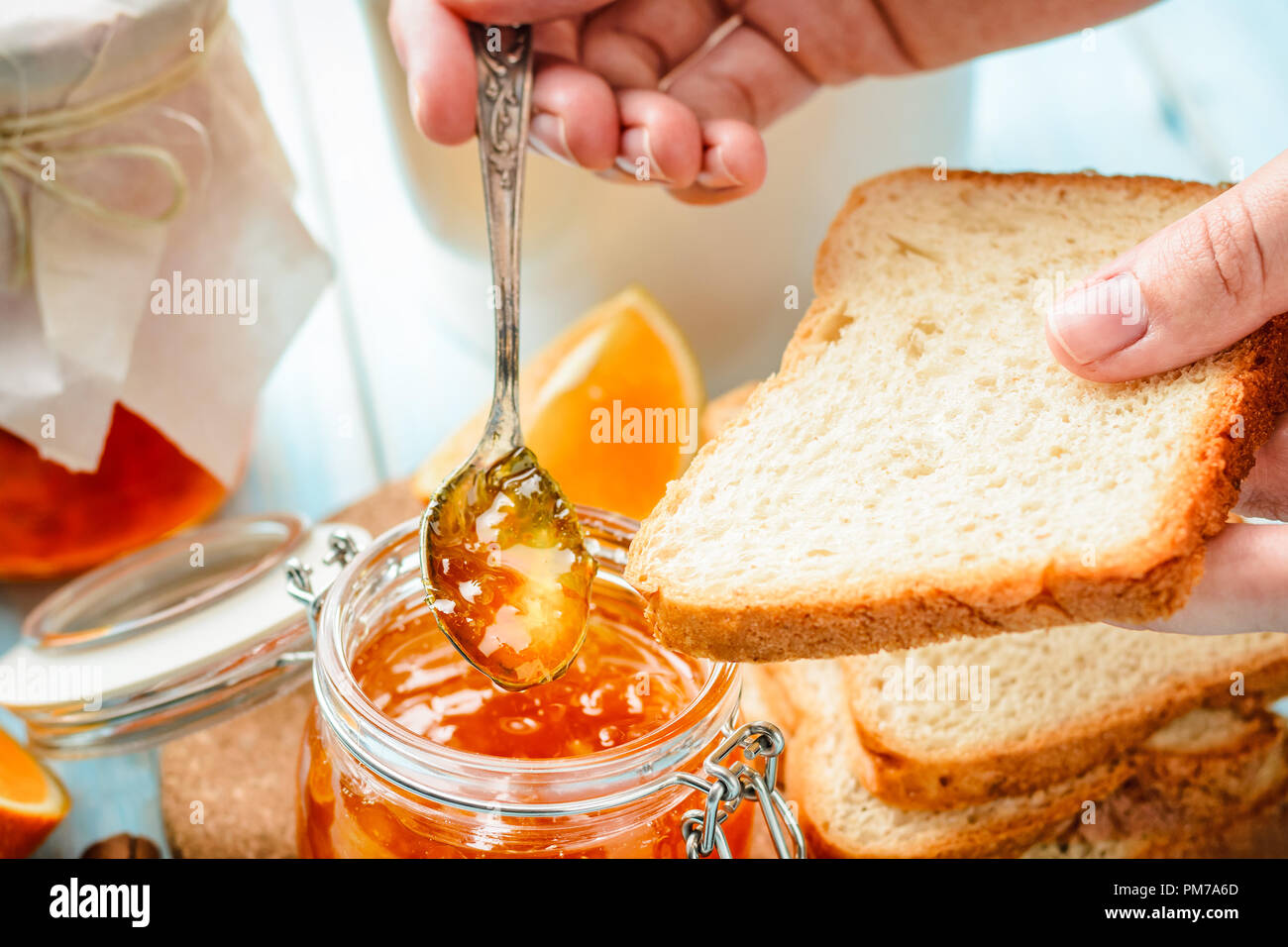 Donna di strisci mano brinda con fatti in casa orange jam Foto Stock