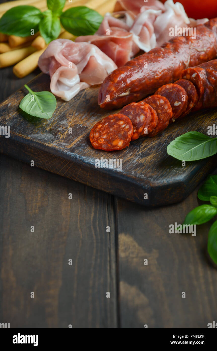 Il salame chorizo. Spagnolo tradizionale il salame chorizo con erbe fresche e pomodori. Foto Stock